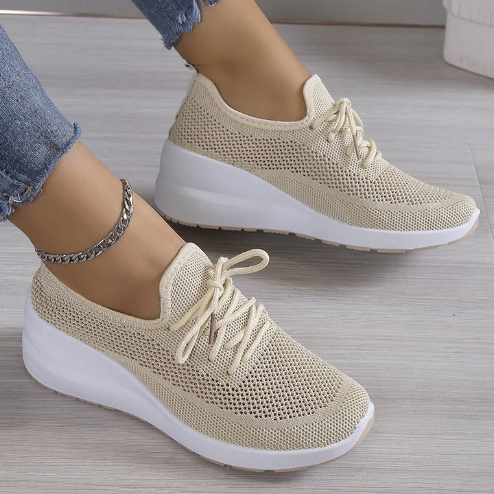 Women's elevated platform wedge sneakers in a sleek design, perfect for fashion-forward casual wear & comfort.