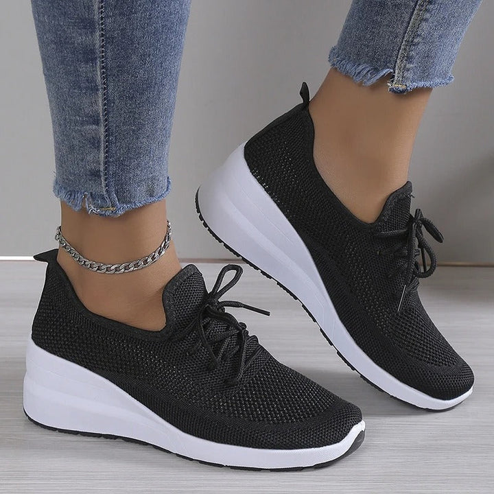 Trendy beige women's platform wedge sneakers, blending comfort with a stylish elevated casual shoe design.