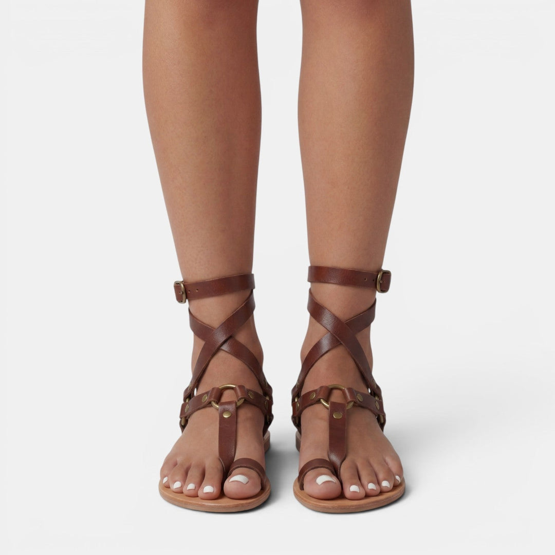 Trendy women's snake print flat sandals featuring stylish crossover straps and adjustable buckles. Casual chic.