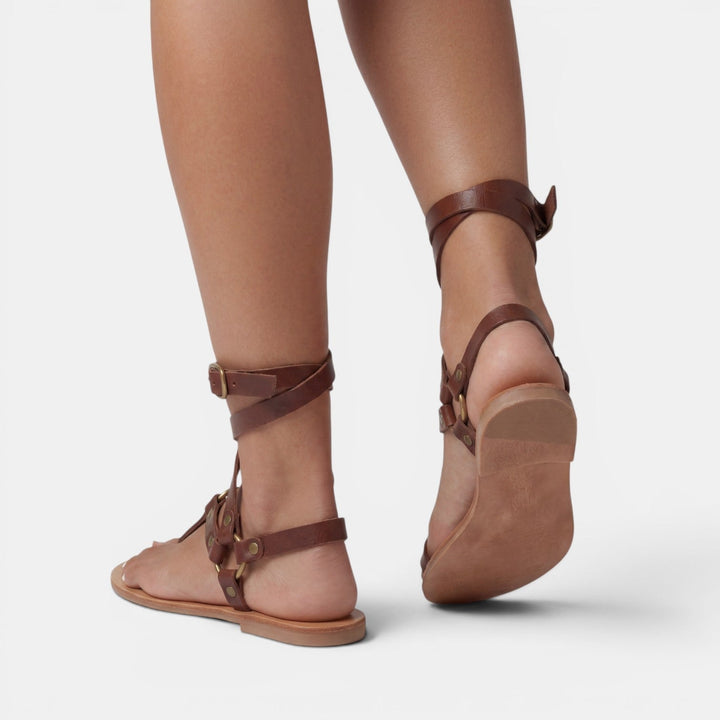 Comfortable snake print flat sandals for women, designed with elegant crossover straps & secure buckles. Summer essential.