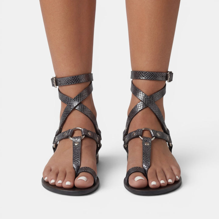 Fashion-forward women's snake print flat sandals. Easy slip-on style with buckled crossover straps for summer chic.