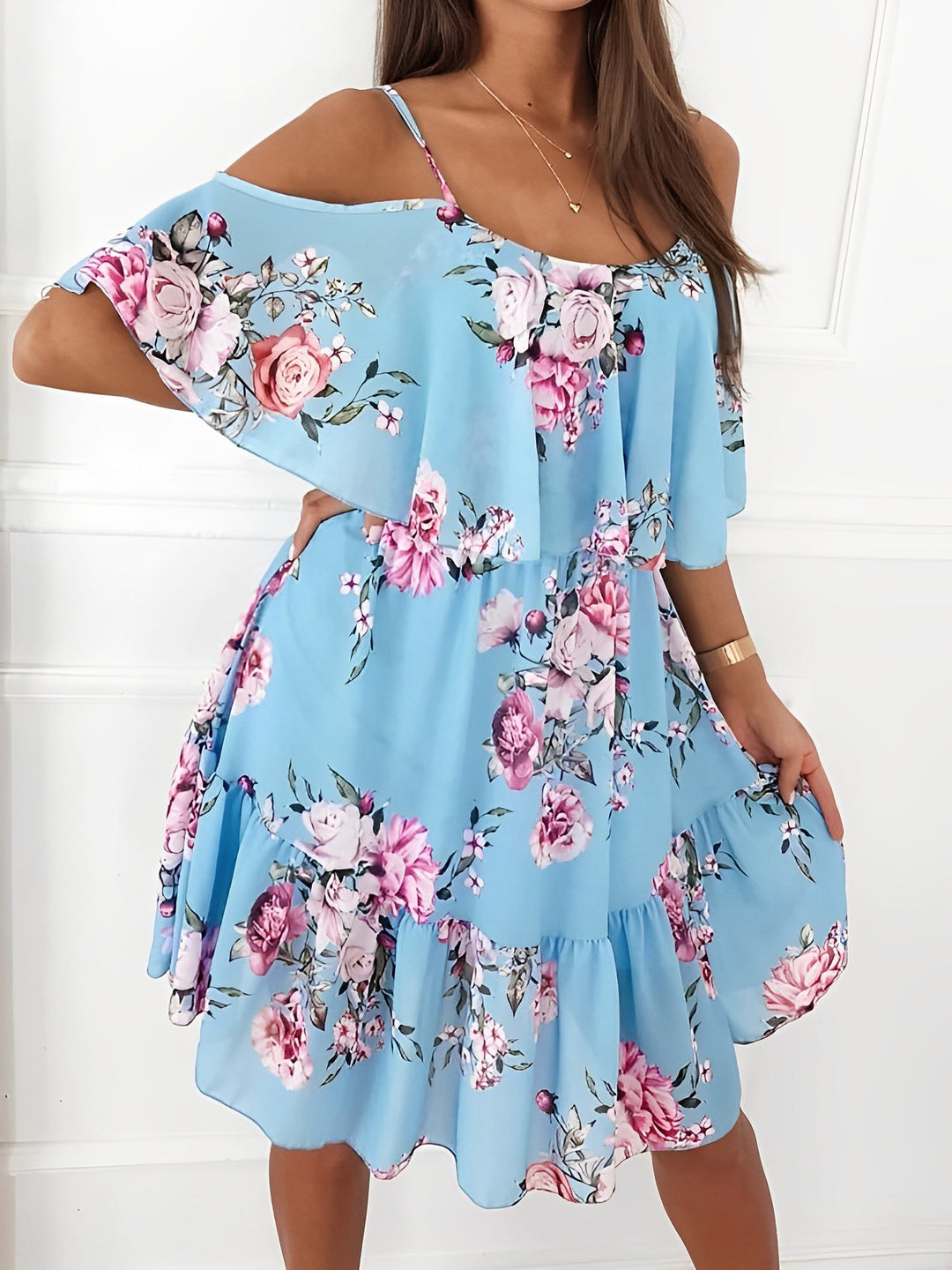 Back view of a women's floral cold shoulder mini dress, showing the flowy silhouette & ruffle details.
