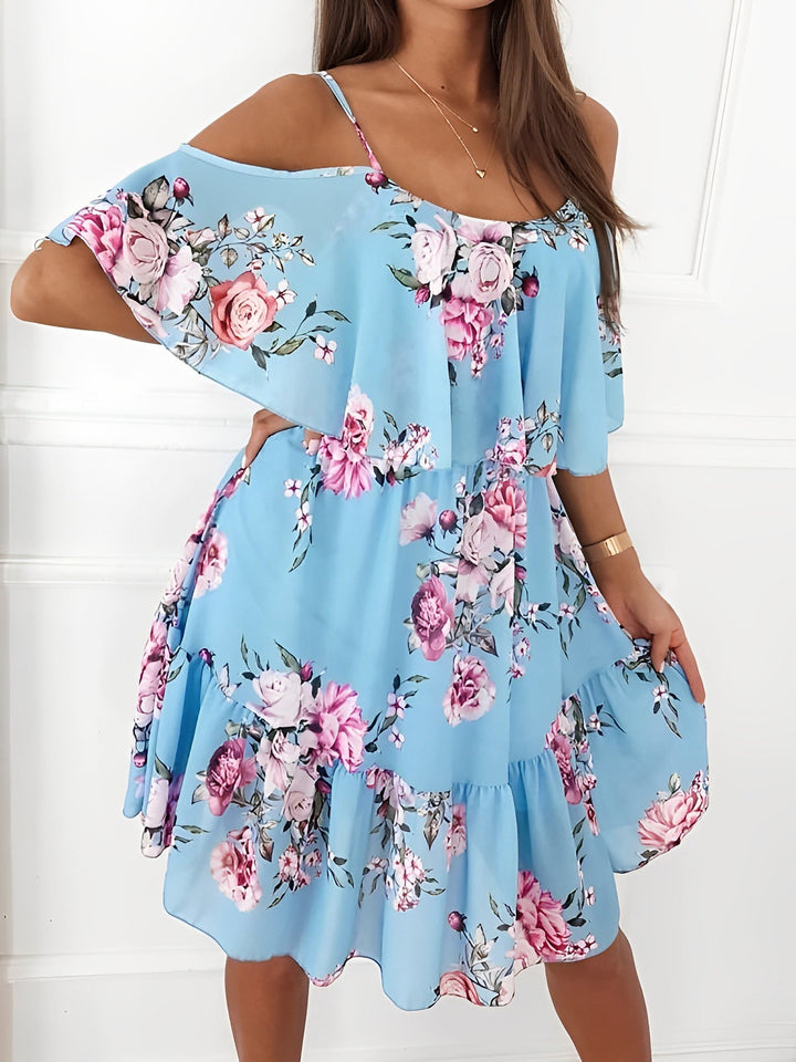 Back view of a women's floral cold shoulder mini dress, showing the flowy silhouette & ruffle details.