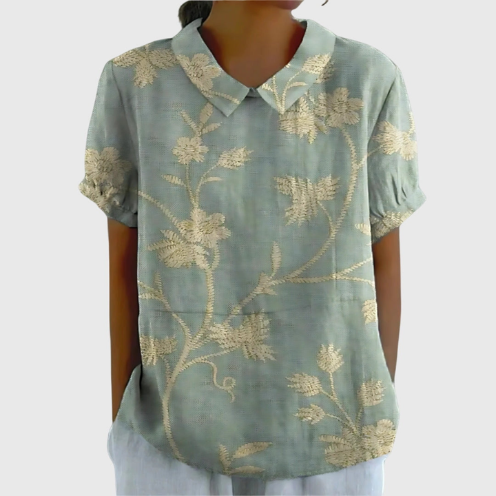 Back view of a women's floral print collared short sleeve blouse. A comfortable and elegant summer top.
