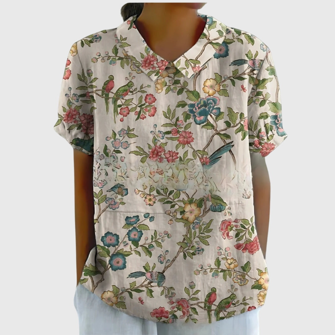 Blue floral print women's collared shirt. Stylish short sleeve blouse, ideal for office or elegant casual wear.