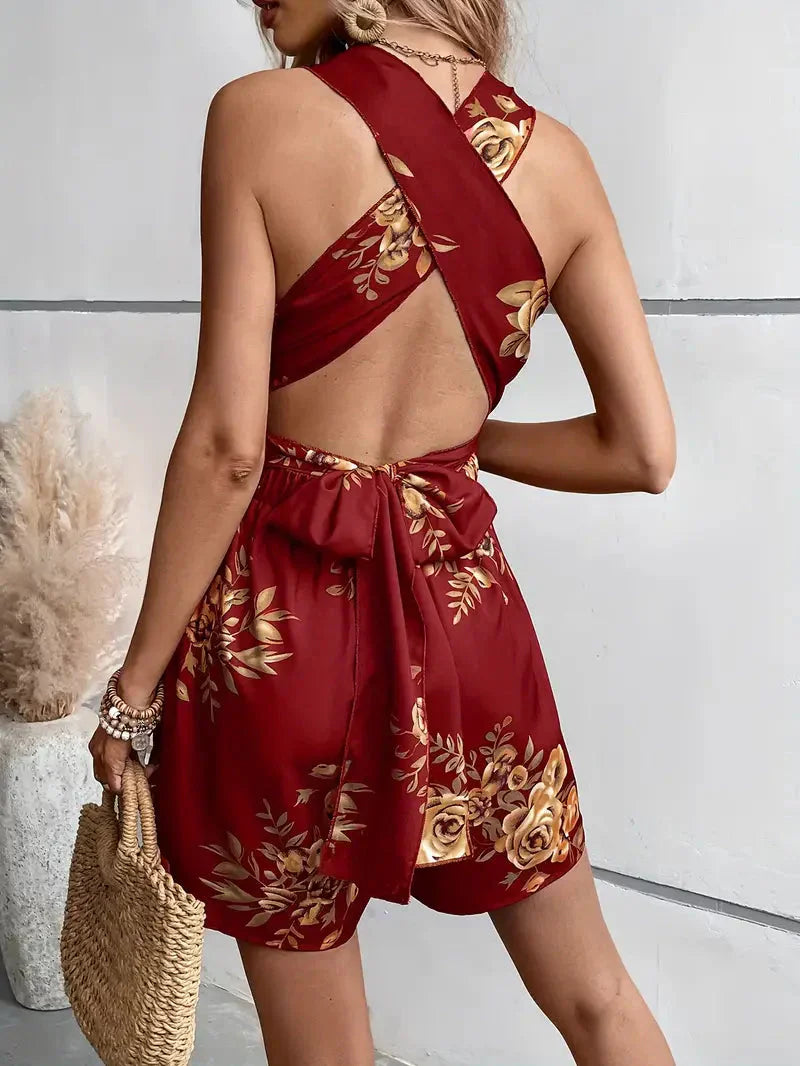 Chic open-back floral romper, versatile for day or evening summer wear.