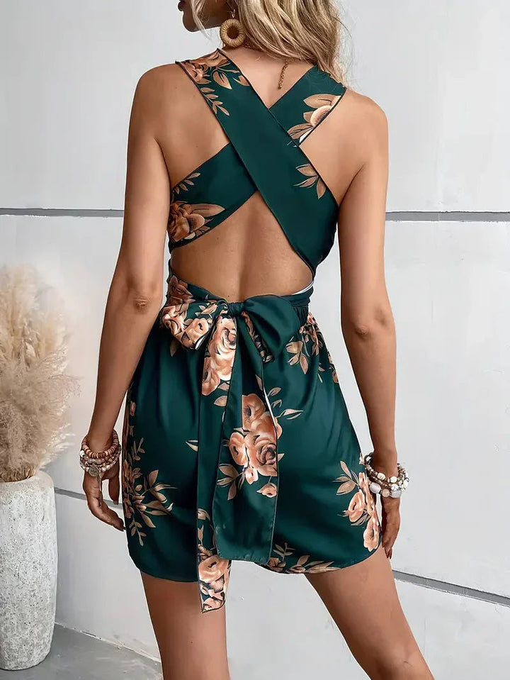 Vacation-ready mini floral romper, featuring a trendy open-back design.