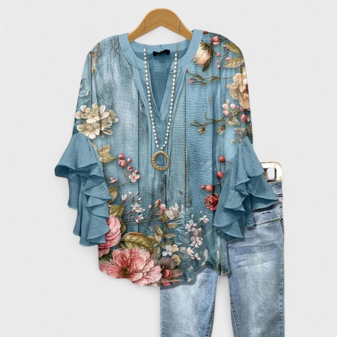 Vibrant floral V-neck women's blouse featuring charming ruffle sleeves. A versatile top for elegant casual chic.
