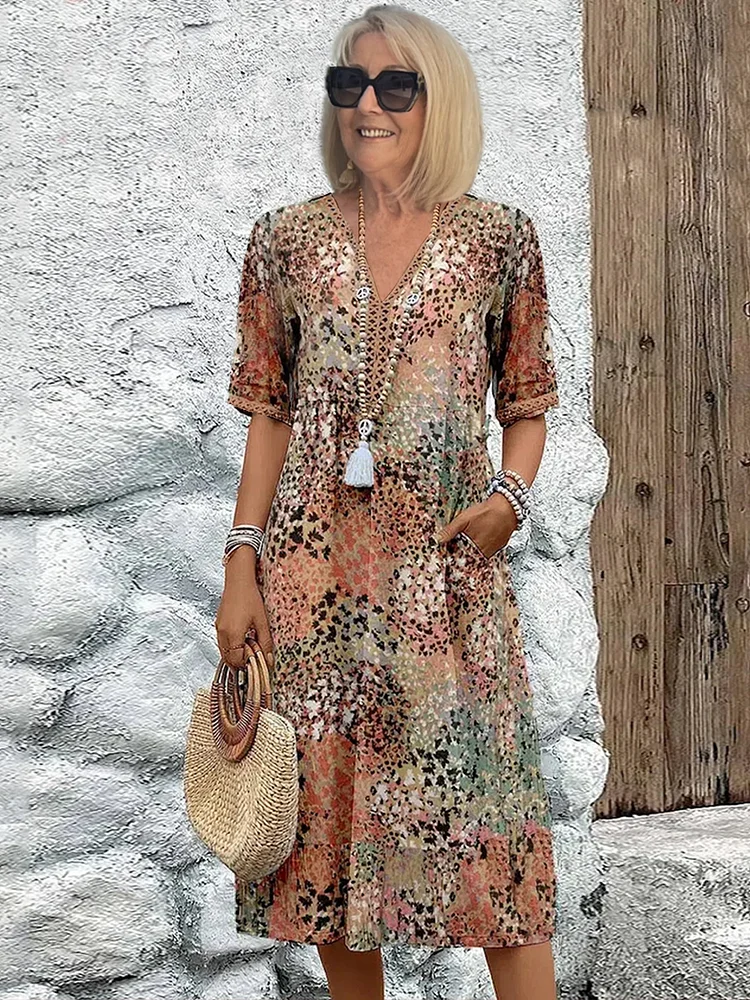 Close-up of women's floral midi dress print, showcasing its vibrant pattern, V-neckline, & soft fabric.