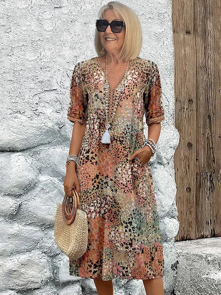 Close-up of women's floral midi dress print, showcasing its vibrant pattern, V-neckline, & soft fabric.