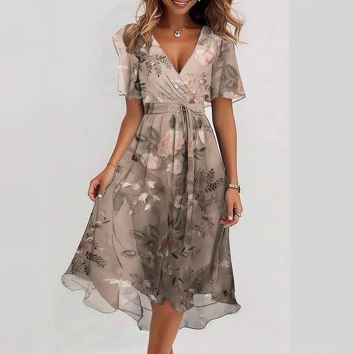 Stylish women's floral wrap midi dress, perfect for summer. Features a feminine design, flutter sleeves & V-neck.