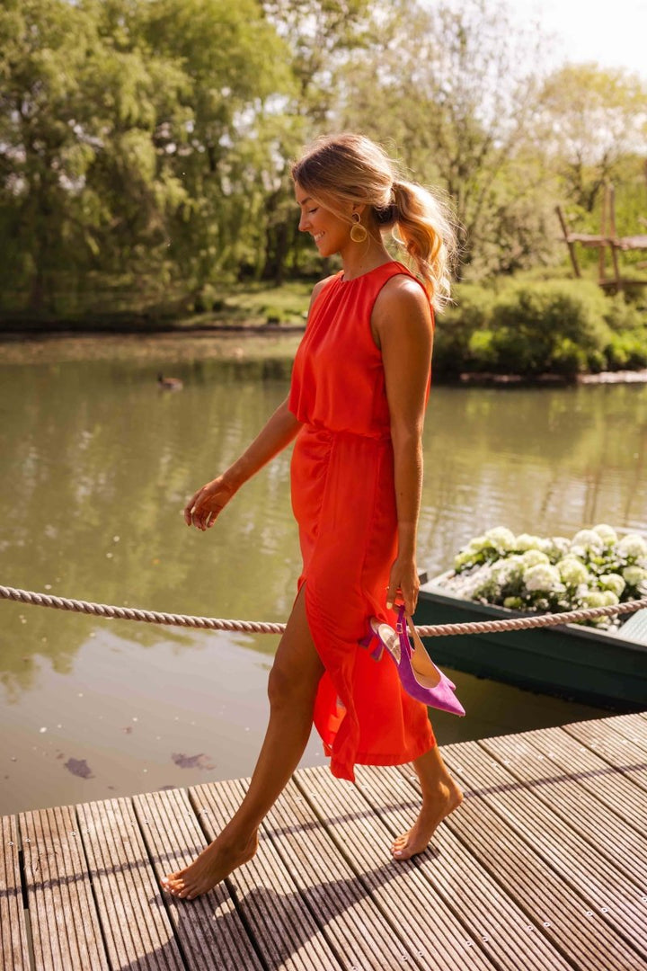 Elegant women's strappy flowing midi dress in vibrant orange. Ideal for summer vacations & events.