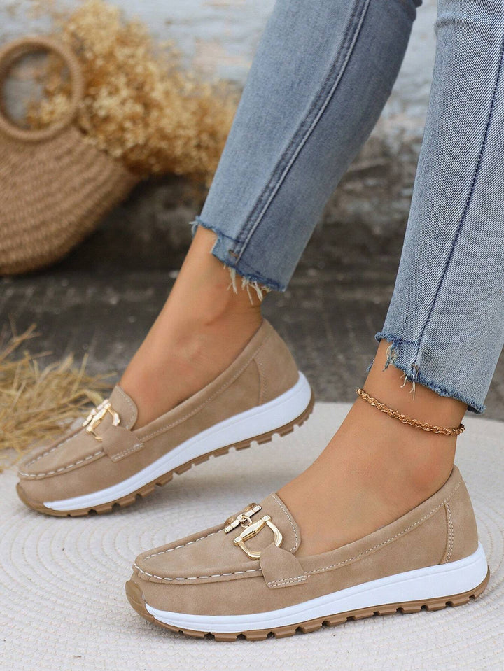 Fashionable women's gold buckle loafers. Comfortable slip-on flats designed for versatile smart casual wear.