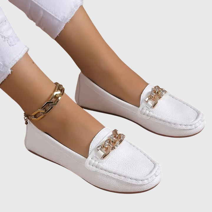 Sophisticated women's slip-on wedge loafers featuring a gold chain.