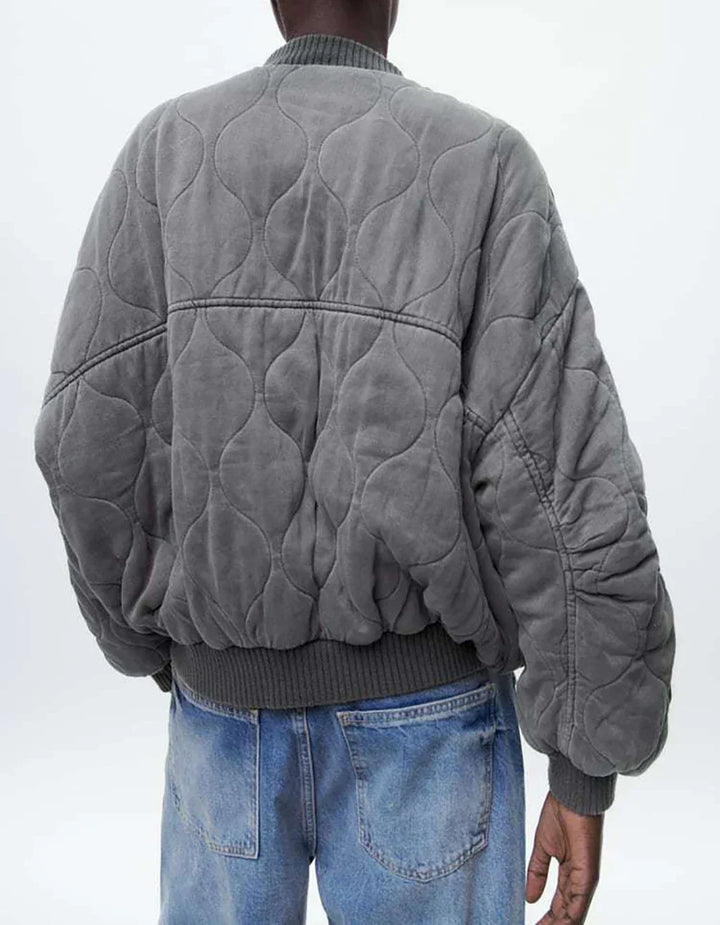 Close-up of a women's gray quilted bomber jacket texture, ideal for casual fall fashion & comfort.