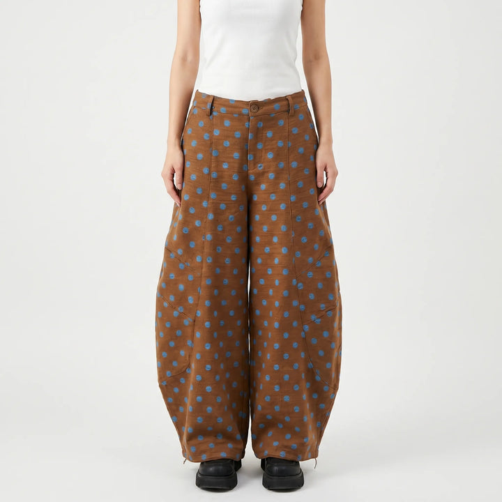 Stylish women's black and white polka dot barrel-leg pants. Trendy wide-leg cut, ideal for spring fashion.