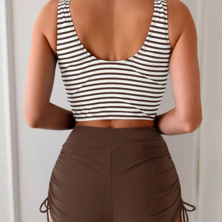 Women's high-waisted tankini, cross-wrap top, two-piece swimwear, flattering fit for beach fashion.