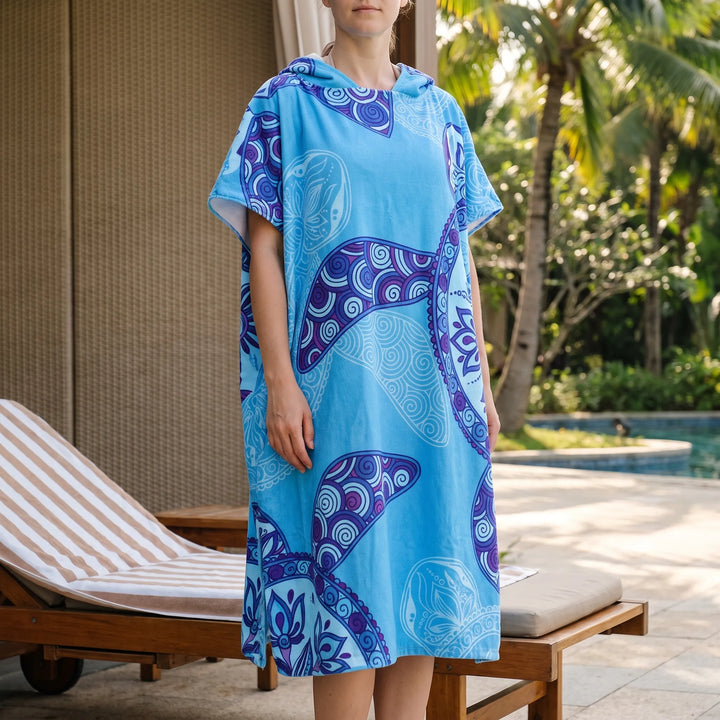 Women's hooded changing robe poncho with vibrant tropical print, ideal for beach, swim, and post-surf comfort.