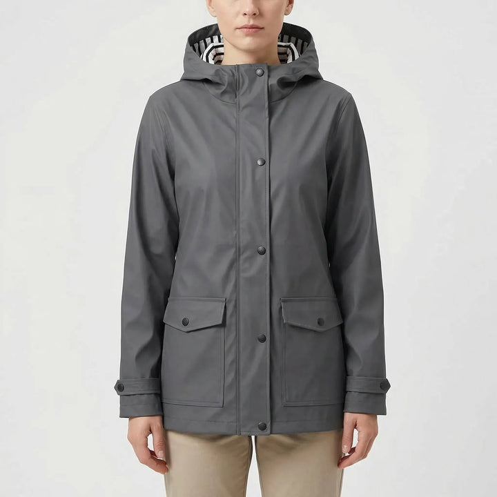 Hooded women's waterproof rain jacket, essential outdoor gear for all-weather hiking & adventure.