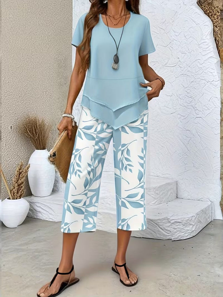 Stylish women's leaf print two-piece set featuring a relaxed fit top & cropped pants, perfect for vacation.