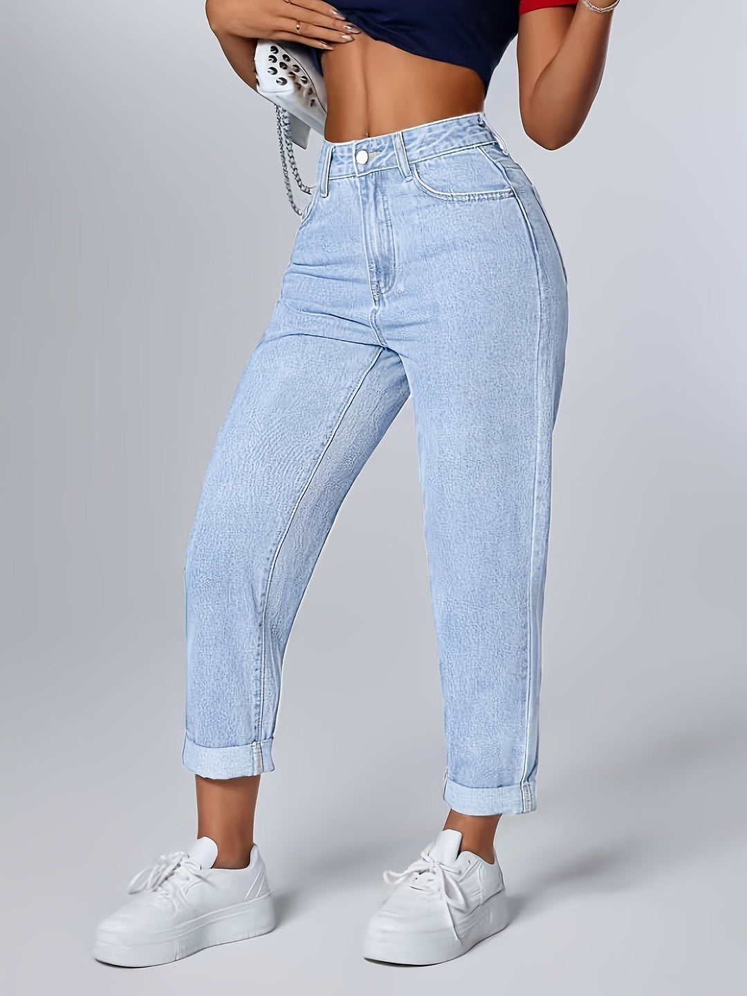 Casual women's light blue mom jeans, high waisted with a relaxed fit. Tapered leg for a retro, everyday look.