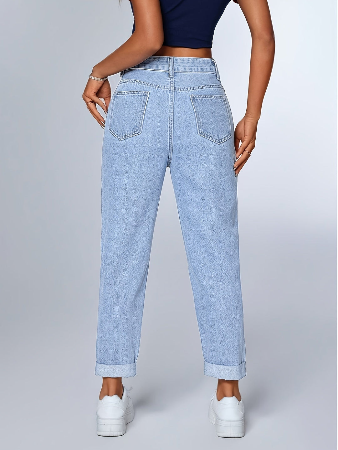 Relaxed fit light blue high waist mom jeans for women, featuring a tapered leg and cuffed hem. Retro casual style.
