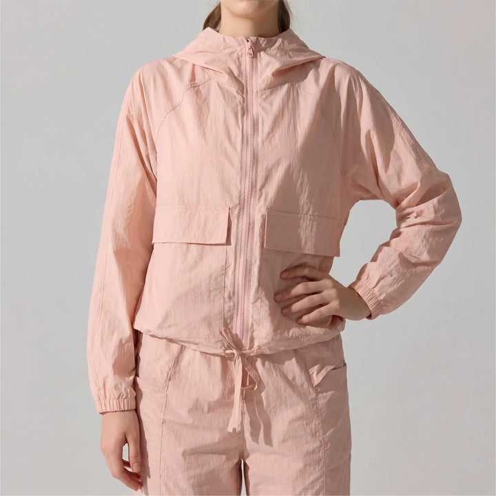 Close-up of lightweight, wind-resistant fabric on women's hooded sports jacket for gym & outdoor.