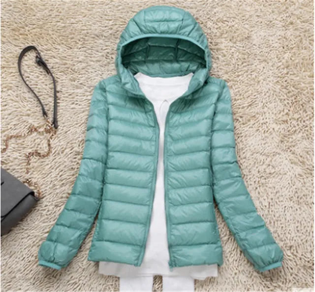 Zipper & pocket detail on women's lightweight hooded puffer jacket, practical design.