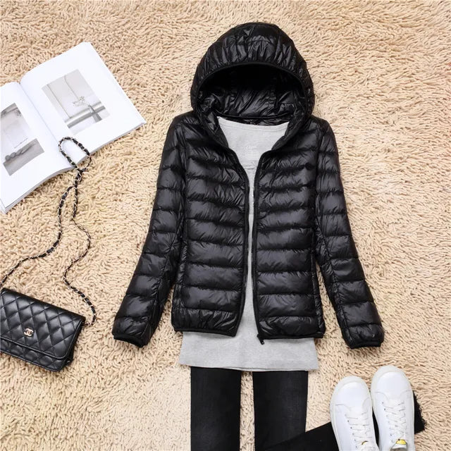 Woman walking in city wearing stylish hooded puffer jacket, casual urban fall outerwear.