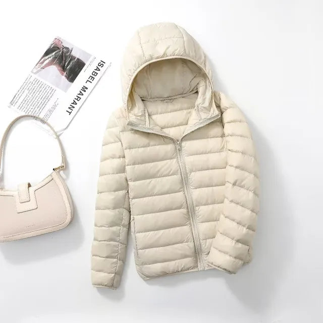 Compact women's packable puffer jacket with hood, perfect for travel & easy storage.
