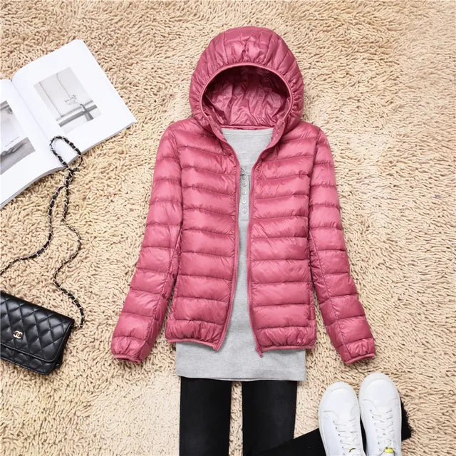 Woman wearing lightweight hooded puffer jacket outdoors, ideal for fall adventures.