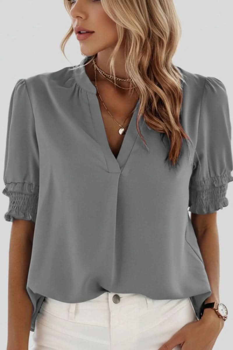 Feminine V-neck blouse with stylish puff short sleeves, a lightweight top for versatile summer styling.