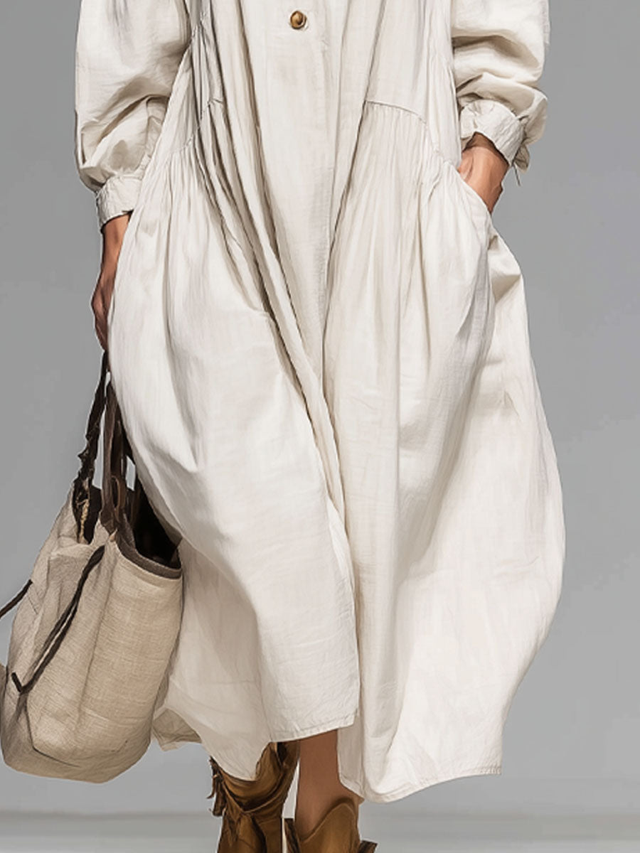 Relaxed women's button-front midi dress, featuring a loose fit, long sleeves, and convenient pockets for comfort.