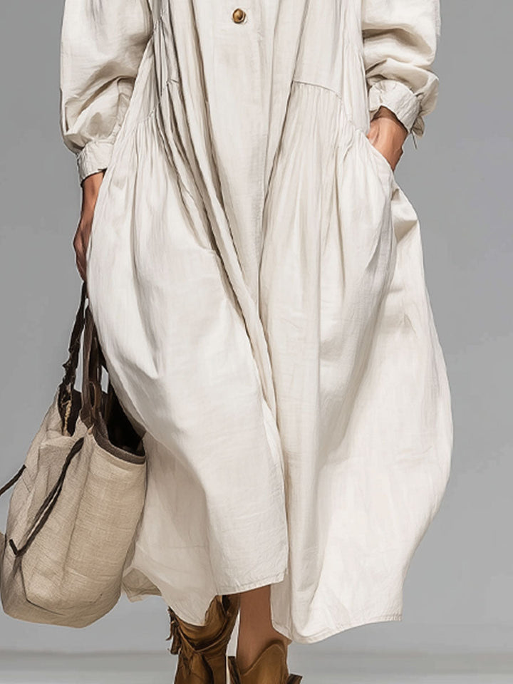 Relaxed women's button-front midi dress, featuring a loose fit, long sleeves, and convenient pockets for comfort.