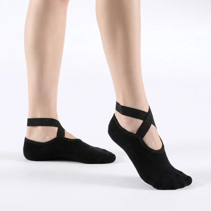 Woman demonstrating non-slip textured yoga socks during a studio workout. Provides stability, grip, and comfort for activewear.