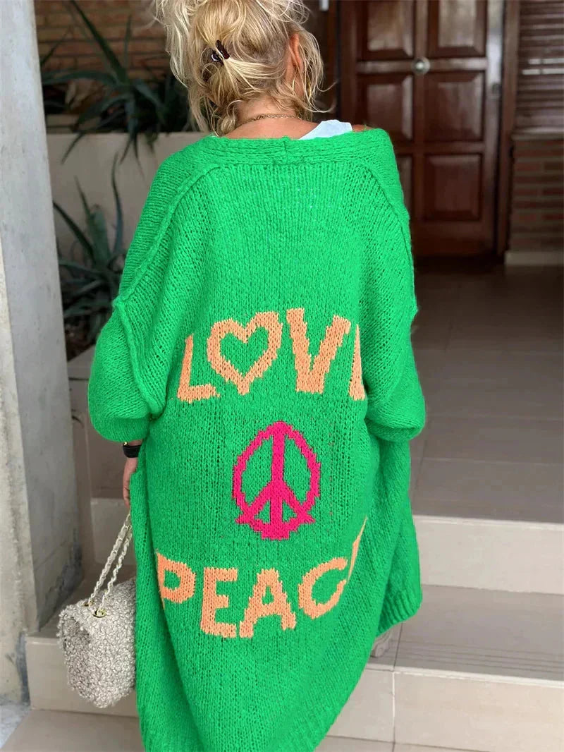 Women's "Peace Love" slogan knit longline cardigan, vibrant colors, oversized, boho chic outerwear.