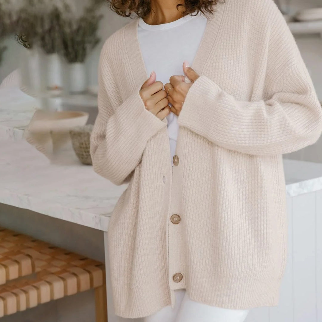 Back view of a women's relaxed fit knit cardigan, highlighting its cozy long sleeve design.