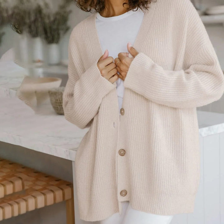 Back view of a women's relaxed fit knit cardigan, highlighting its cozy long sleeve design.