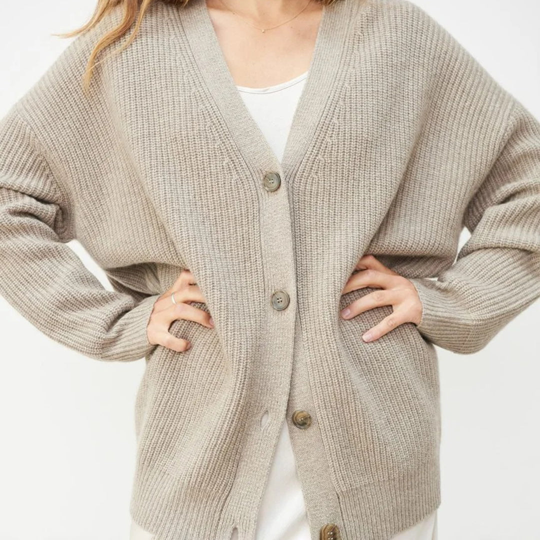 Close-up of buttons on an oversized V-neck women's cardigan, detailed for stylish wear.