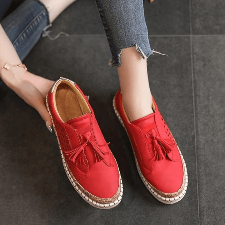 Enjoy summer with these breathable women's perforated slip-on sneakers. Comfort, style, and tassel accents for fashion.