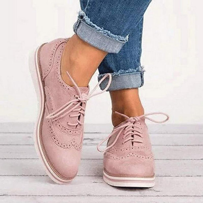 Women's pink lace-up Oxford sneakers with classic brogue detail. Stylish & comfortable casual footwear for everyday wear.