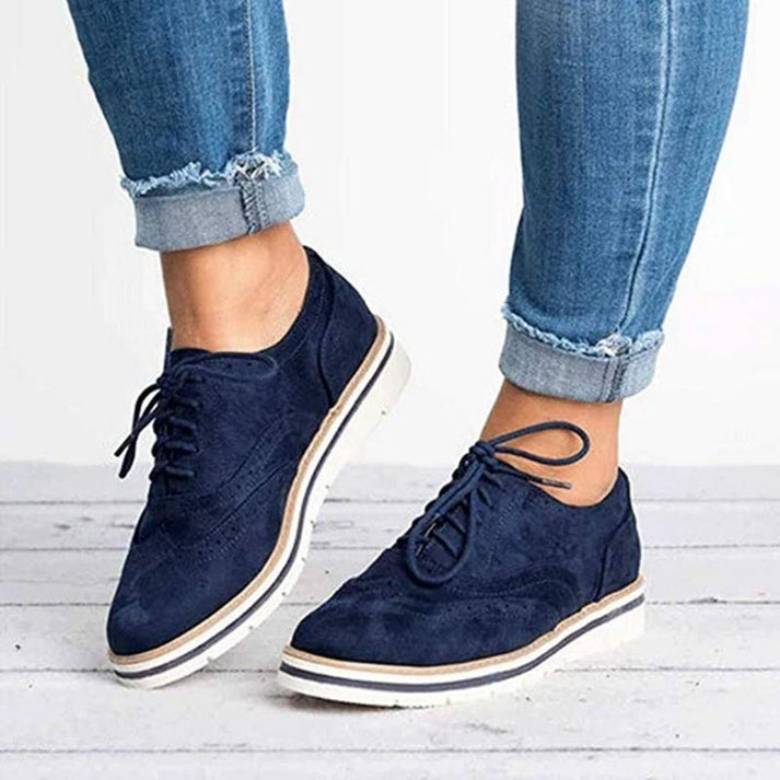 Blue women's lace-up Oxford sneakers with brogue detail. Comfortable & fashionable everyday footwear, vintage style.