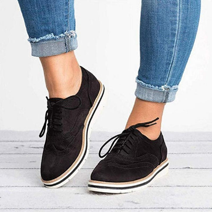 Grey women's lace-up Oxford sneakers featuring elegant brogue detail. Comfortable, stylish, smart casual everyday shoes.