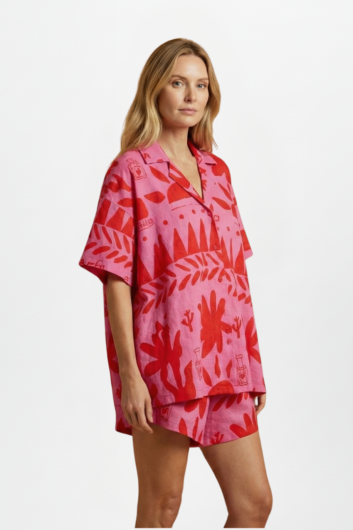 Women's pink tropical print camp collar shirt & high-waisted shorts set. Vibrant summer style, resort & beachwear.