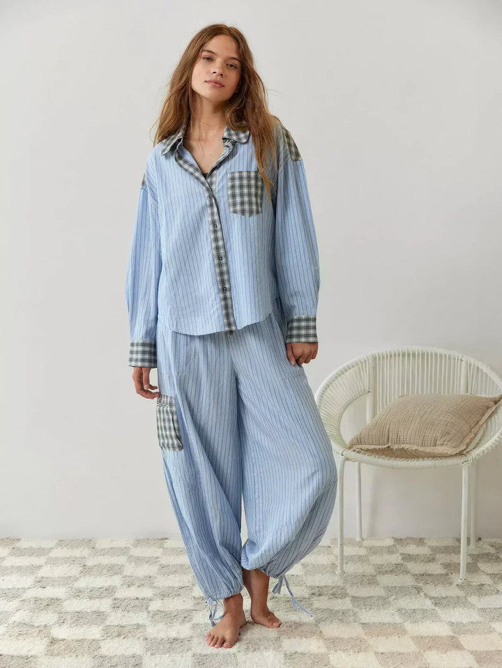 Women's two-piece plaid sleepwear set; a long-sleeve button-up top and matching relaxed fit bottoms for home wear.