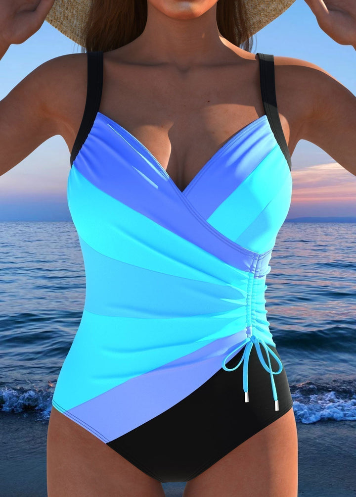 Woman posing in a flattering printed surplice one-piece swimsuit with tummy control, ideal for vacation.