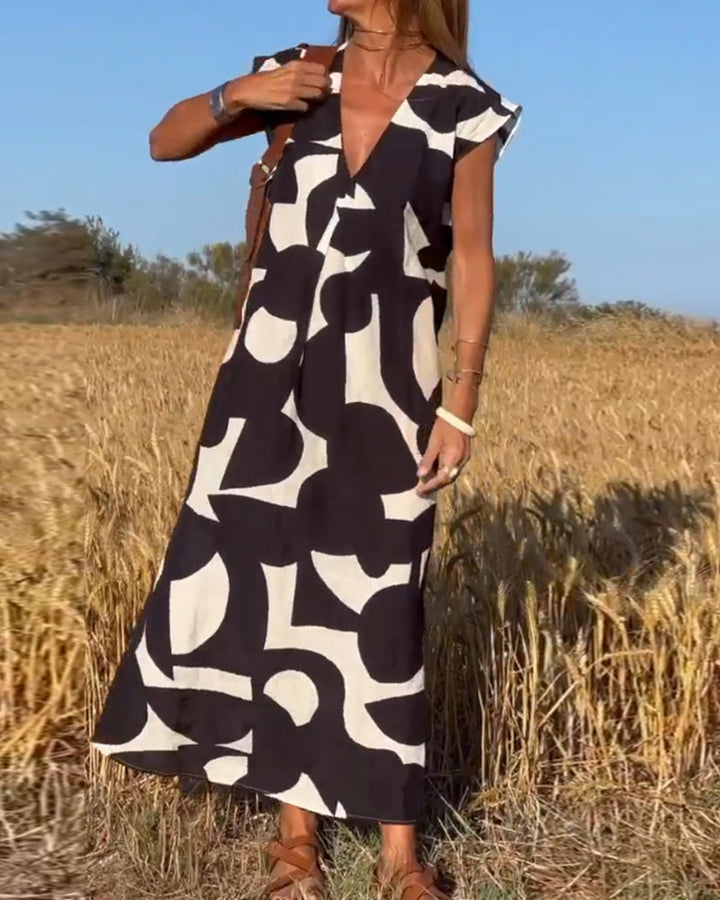 Women's summer V-neck dress with abstract print, relaxed and breezy for warm weather comfort.