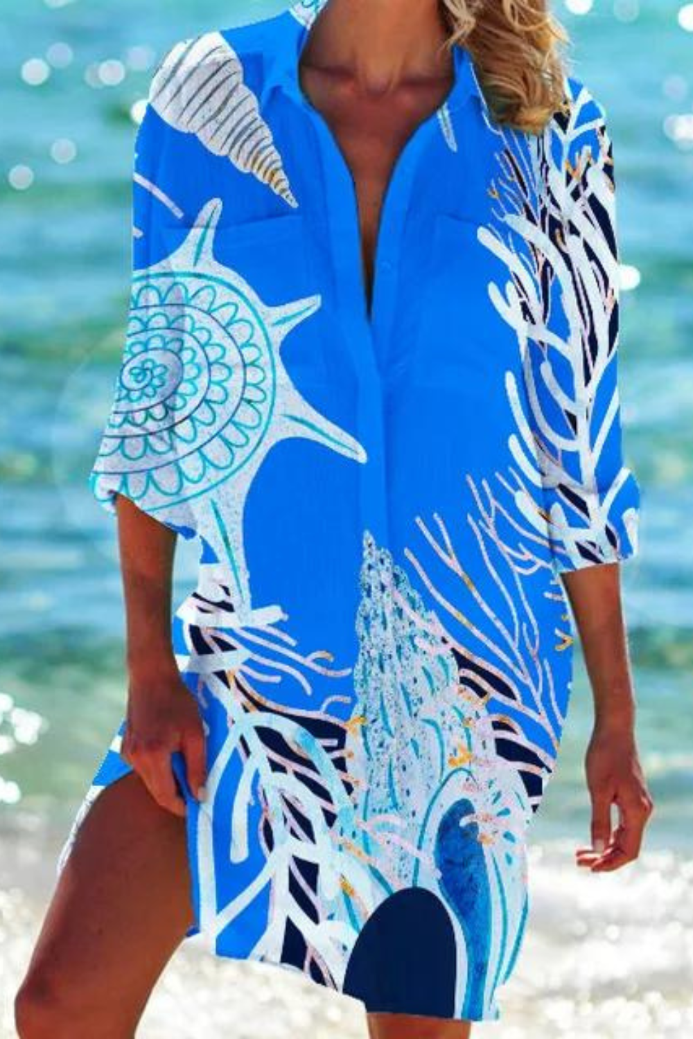 Women's coastal beach cover up featuring a vibrant seashell and coral print. Relaxed fit for summer resort.