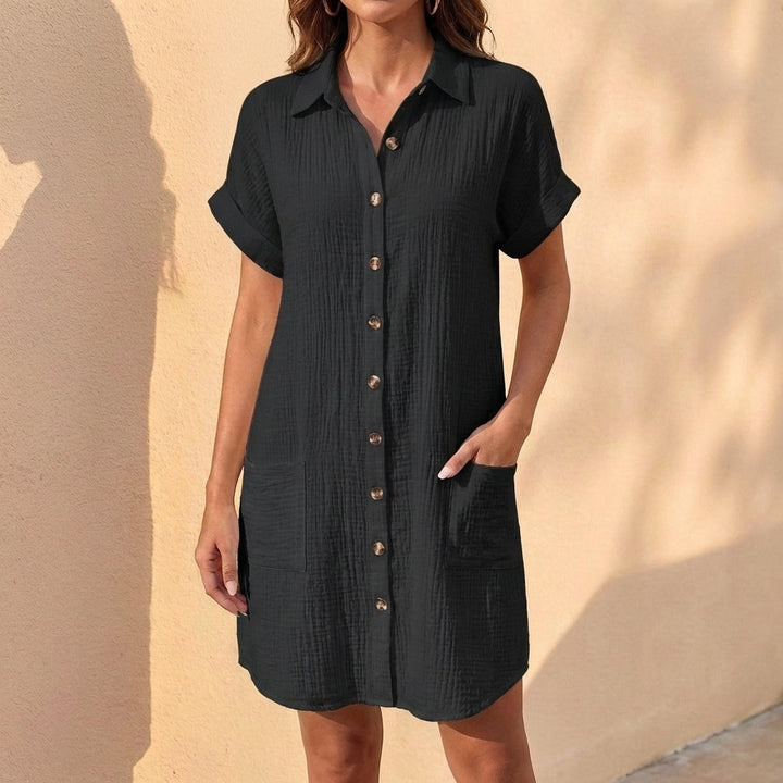 Woman wearing a versatile relaxed fit midi shirt dress. Casual, collared, short cuffed sleeves, ideal for day.