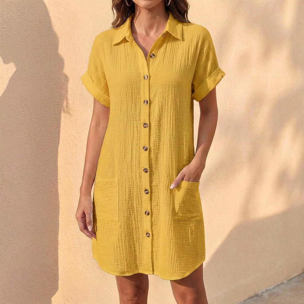 Close-up of cuffed short sleeves & button-front detail on a women's relaxed fit midi shirt dress. Summer style.